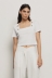 T-shirt crop con dettaglio scollo quadrato con bottoni oro logati • Bianco