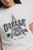 T-shirt paricollo con stampa logo e applicazione strass neri • Bianco
